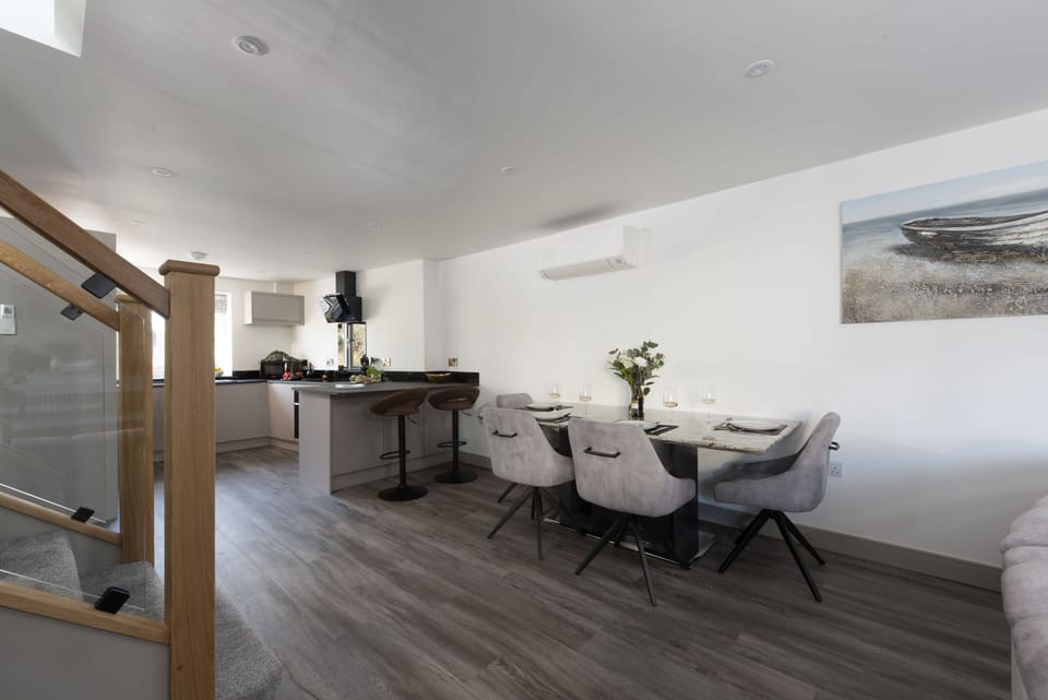 Tiddlywink, Newquay. Ground floor: Sleek interiors, contemporary finishes, and a large dining table
