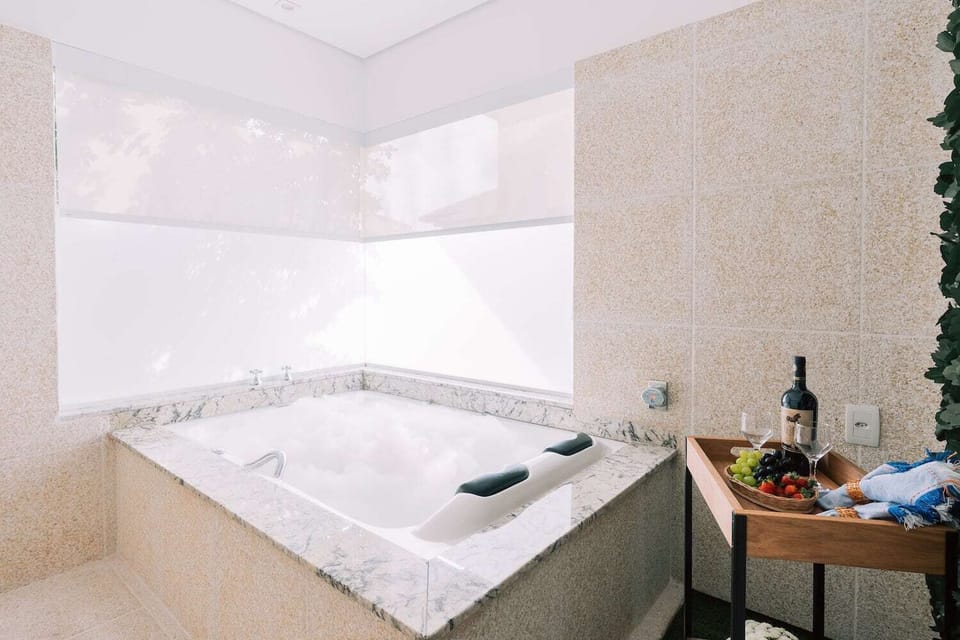 Suite Master com cama queen e banheira de hidromassagem | Bathroom | Shower, hair dryer, towels, soap