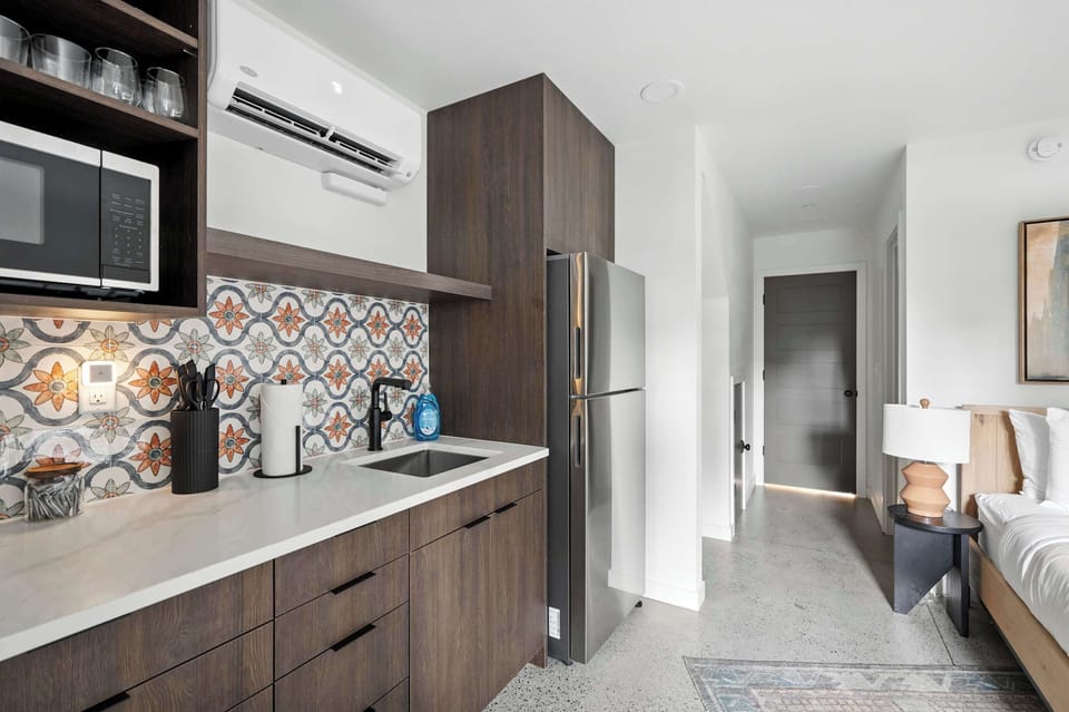 Kitchen with patterned tile and stainless appliances.