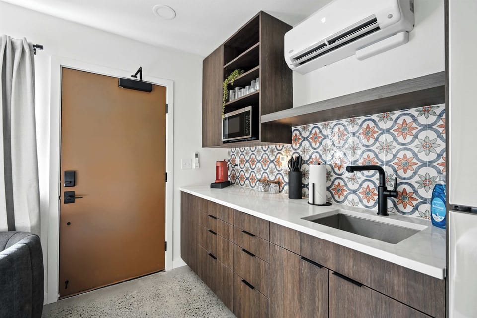 Kitchen counter with patterned tile and entry.