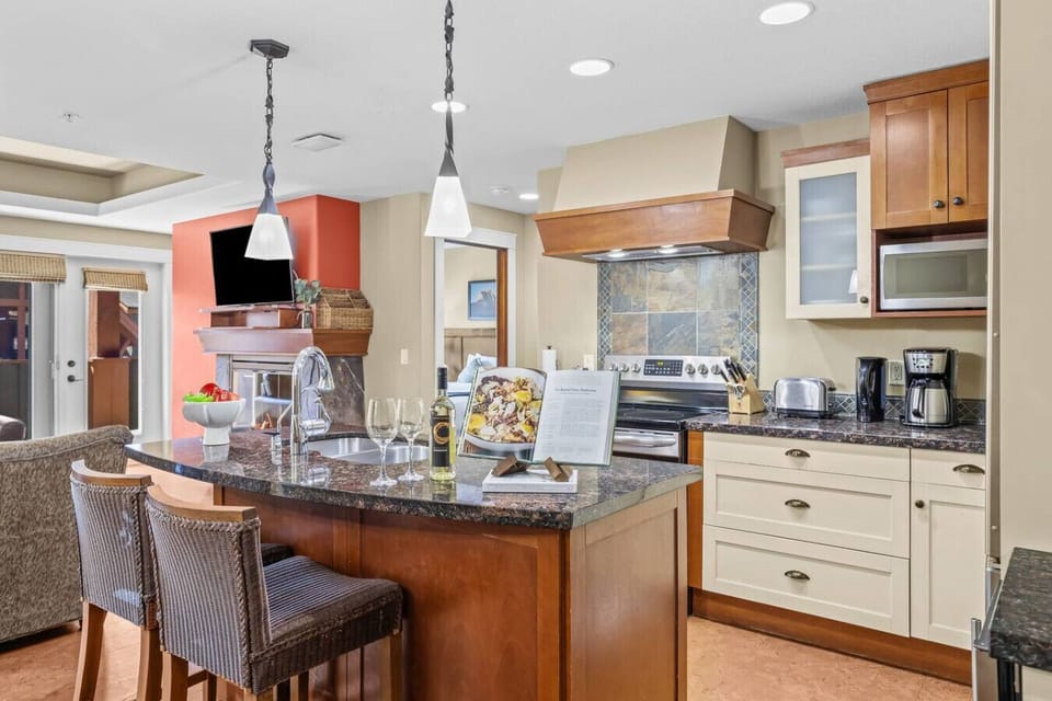 A fully equipped kitchen featuring a breakfast bar with seating for two.