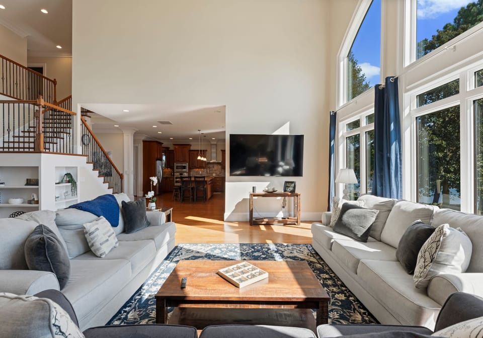 Main sitting area with living room. Three three seater couches, with wall of windows and TV!