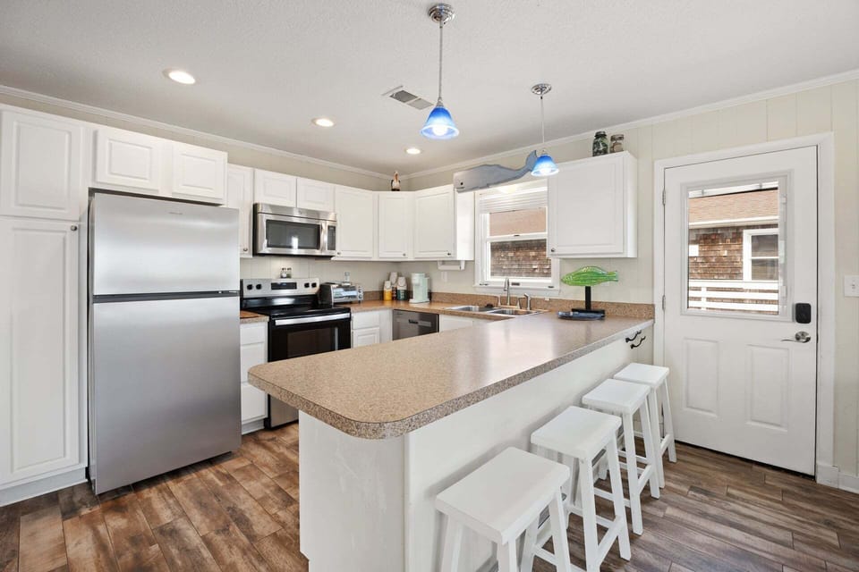 Fully equipped kitchen with modern appliances, a breakfast bar for 3, and everything you need to prepare delicious meals at home.