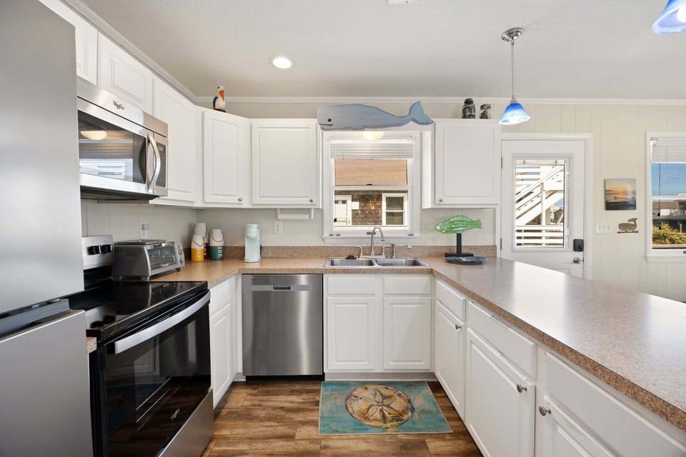 Fully equipped kitchen with modern appliances, a breakfast bar for 3, and everything you need to prepare delicious meals at home.