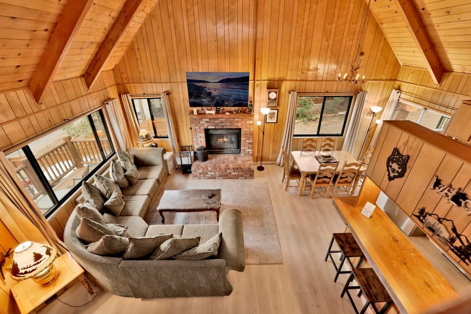 Inviting living room with a beautiful stone fireplace, comfortable couch, and TV, perfect for relaxing after a day of mountain adventures.