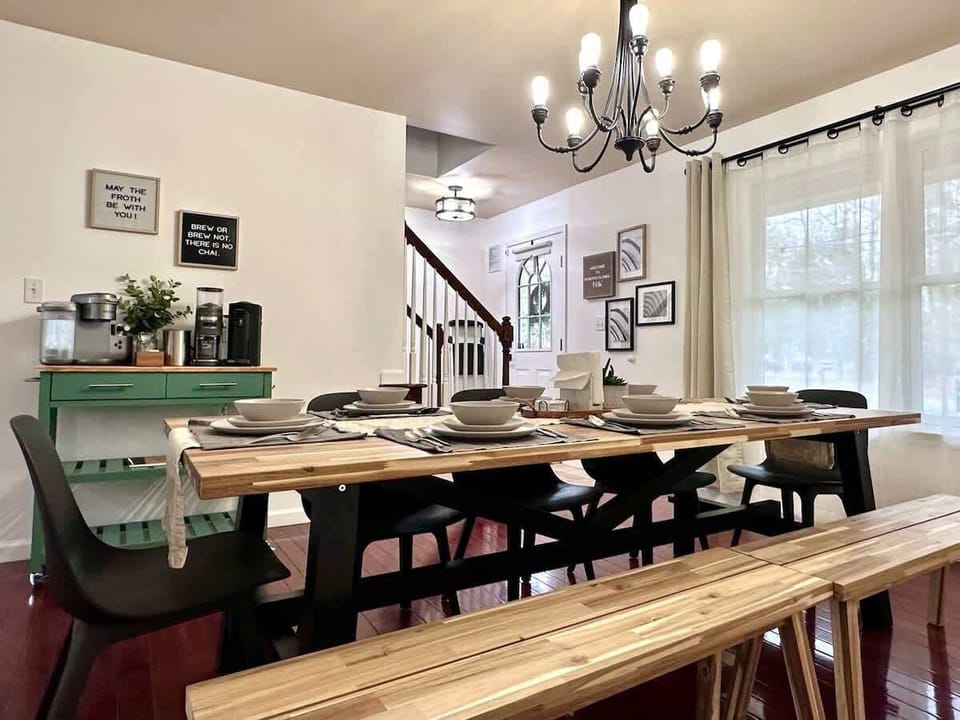 Dining room with large wooden table, wooden benches, and chairs that comfortably seat 8 people. Great for enjoying meals, board games, and each other's company.