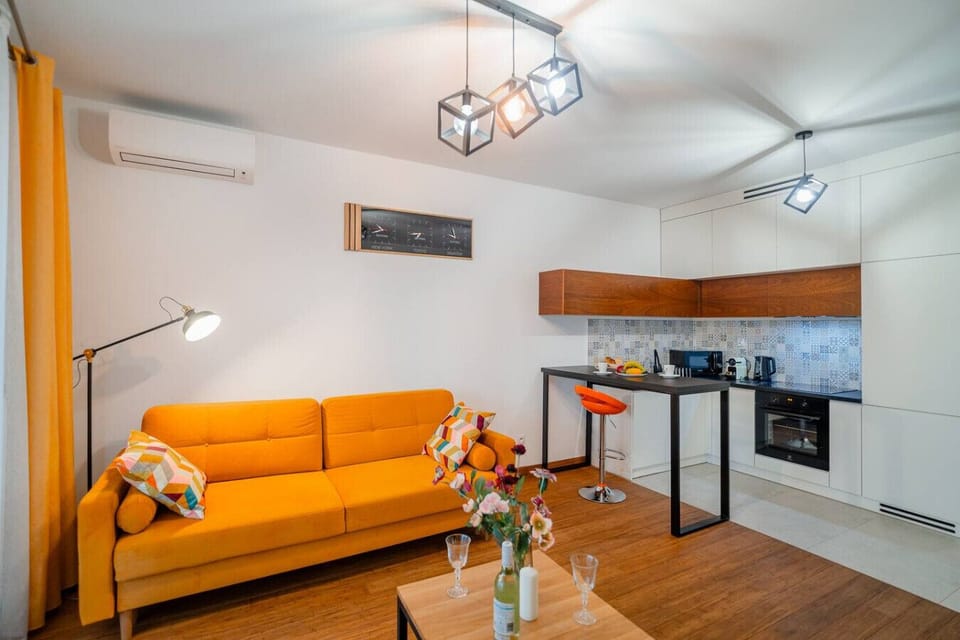 Open-Concept Living Room with Bright Sofa, Modern Kitchen and Large Smart-TV | Book Now with RENTUJEMY.COM