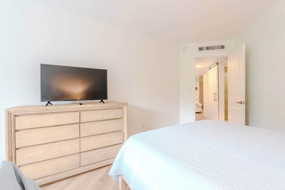 Bright and inviting bedroom with two queen beds, ideal for extra guests.