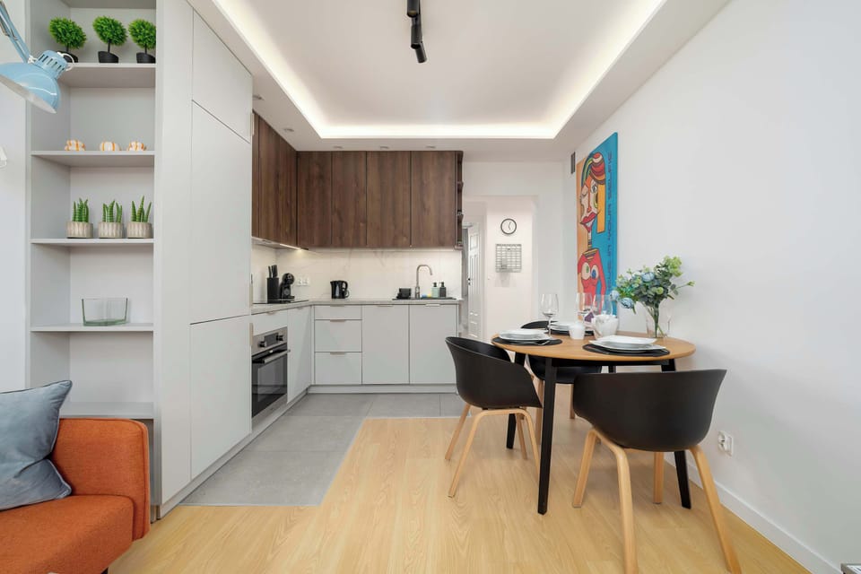 Another angle of the kitchen with the dining area visible. The layout maximizes functionality while keeping the space open.