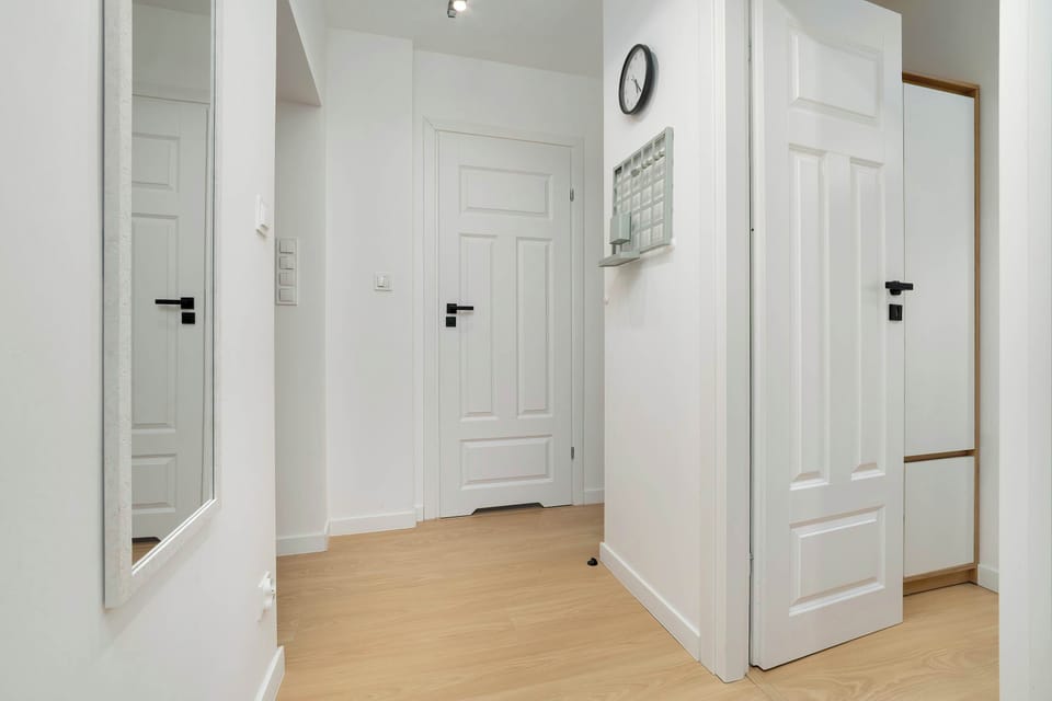 A white hallway with doors leading to different rooms. The clean, bright design creates a welcoming first impression.
