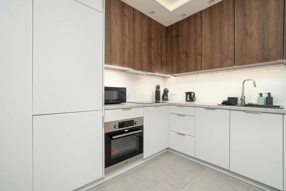 A fully equipped kitchen with modern cabinets, an oven, and a coffee machine. The space is designed for convenient and enjoyable cooking.