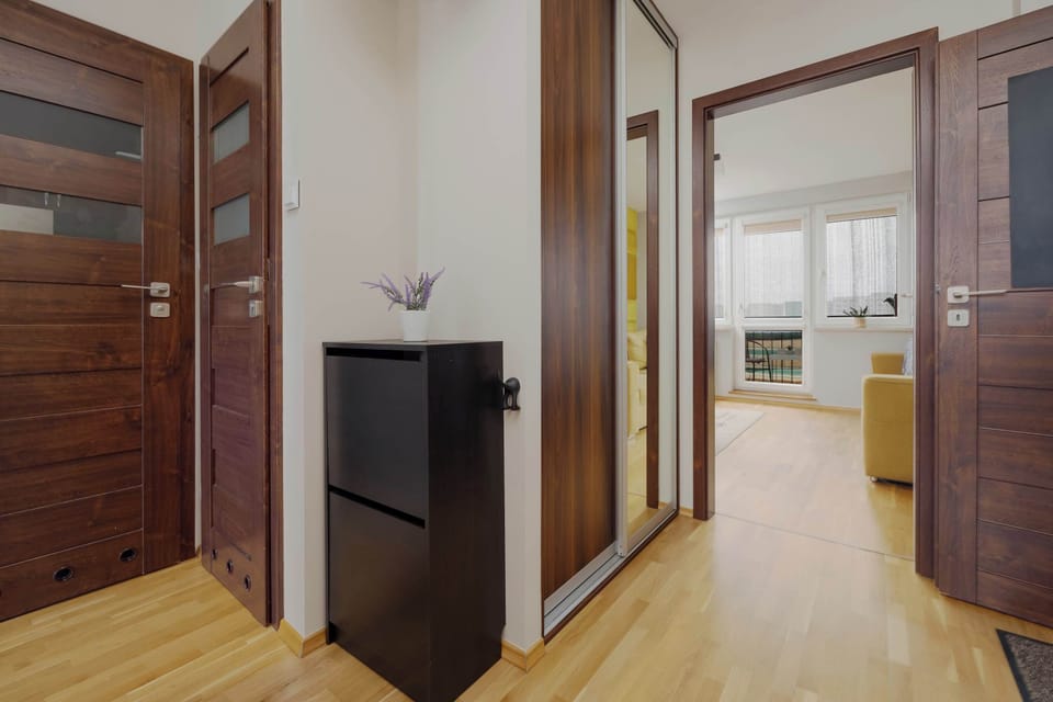 A corridor with warm wooden details connecting several bright interior rooms.