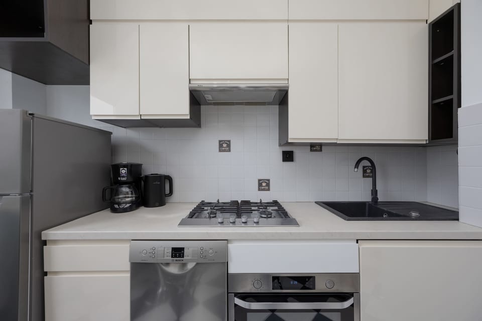 A small kitchen space with integrated appliances and clean, minimalist design.