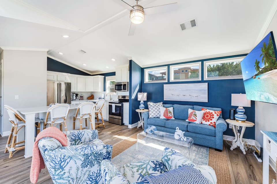 Relax in this coastal-chic living space where ocean blues meet crisp whites. Your open kitchen flows seamlessly into the cozy lounge area.