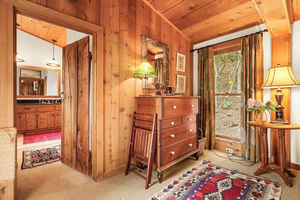 Warmly appointed bedroom with vintage dresser and natural light throughout.