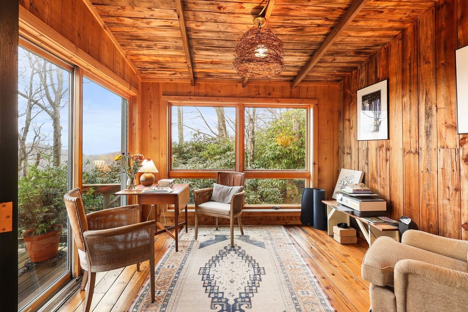 Grand sunroom retreat with wall-to-wall windows and plush seating.