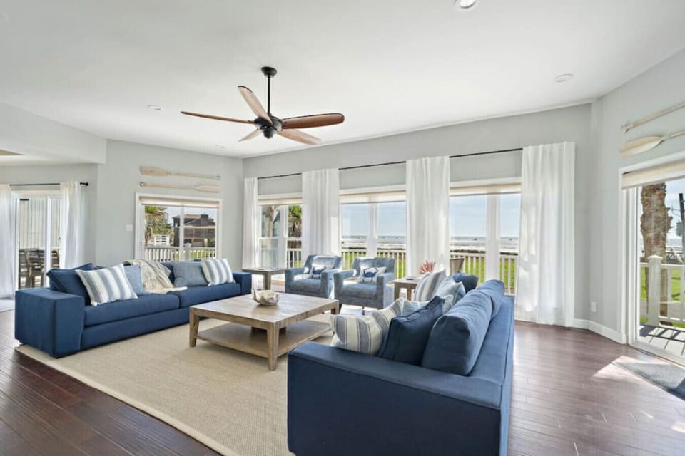 The living room has a 65-inch flatscreen television and ocean views