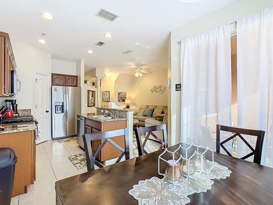Open-concept kitchen and dining area with breakfast bar and patio access, ideal for family meals and gatherings.