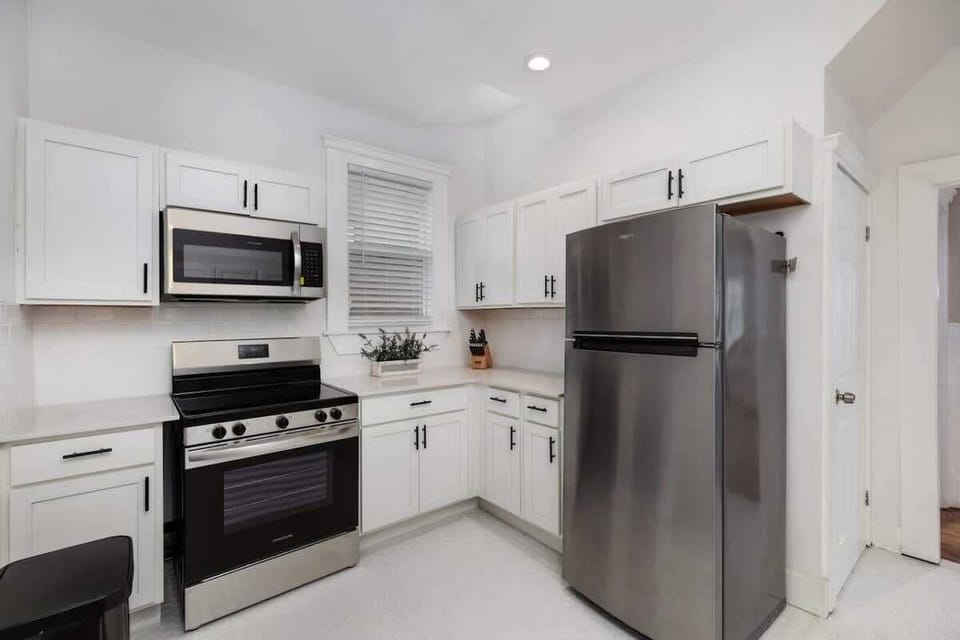 Modern kitchen with induction stove and stainless fridge.