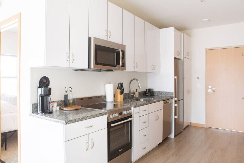 Channel your inner chef in this fully equipped, modern kitchen boasting sleek appliances and a dining table comfortably seating four