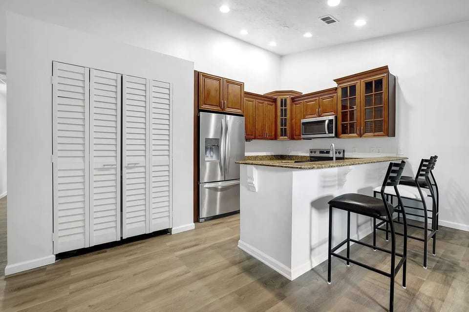 Modern kitchen with white cabinetry, breakfast bar, and convenient bar seating