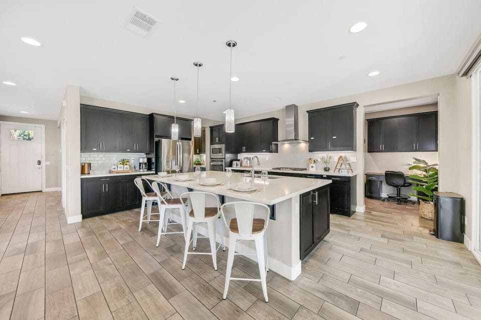 Fully equipped kitchen featuring island seating, double oven, and full-size refrigerator — ideal for group stays