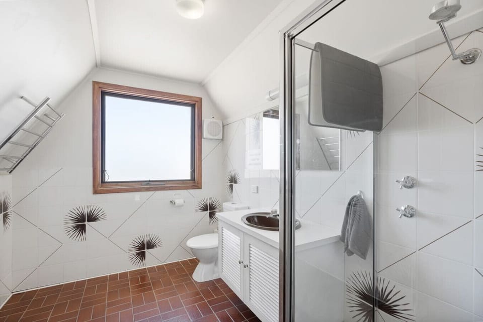 Crisp white tiling, natural light, complimentary toiletries, and a walk-in shower create a refreshing start or finish to the day.