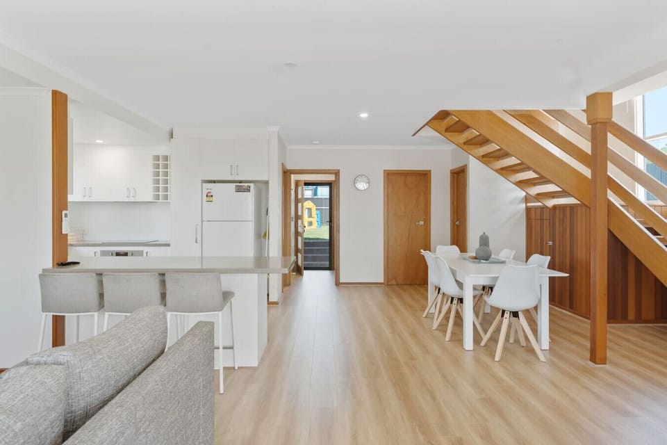 Gather around the six-seater dining table or share breakfast at the island bar, framed by warm timber tones and the inviting flow of open-plan living.