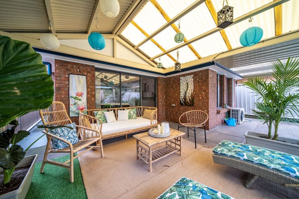 Unwind beneath the covered outdoor entertaining area, where leafy surrounds, sun loungers, outdoor dining, and relaxed lounge seating create the perfect setting for slow afternoons and easy evenings outdoors.
