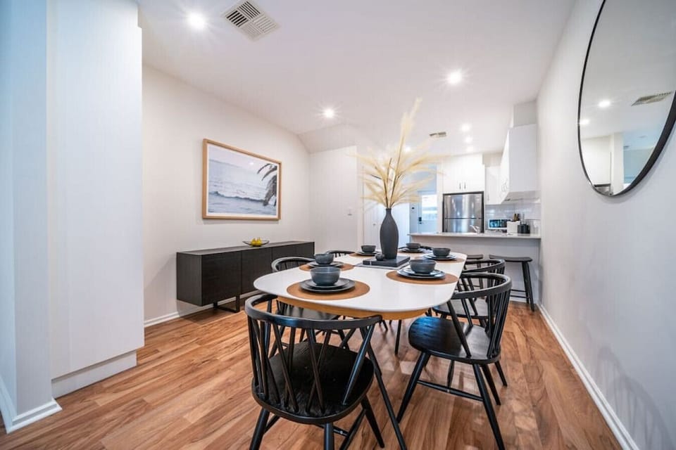 Gather around the six-seater dining table for long dinners, takeaway feasts, or planning the day beneath soft lighting and simple contemporary styling.