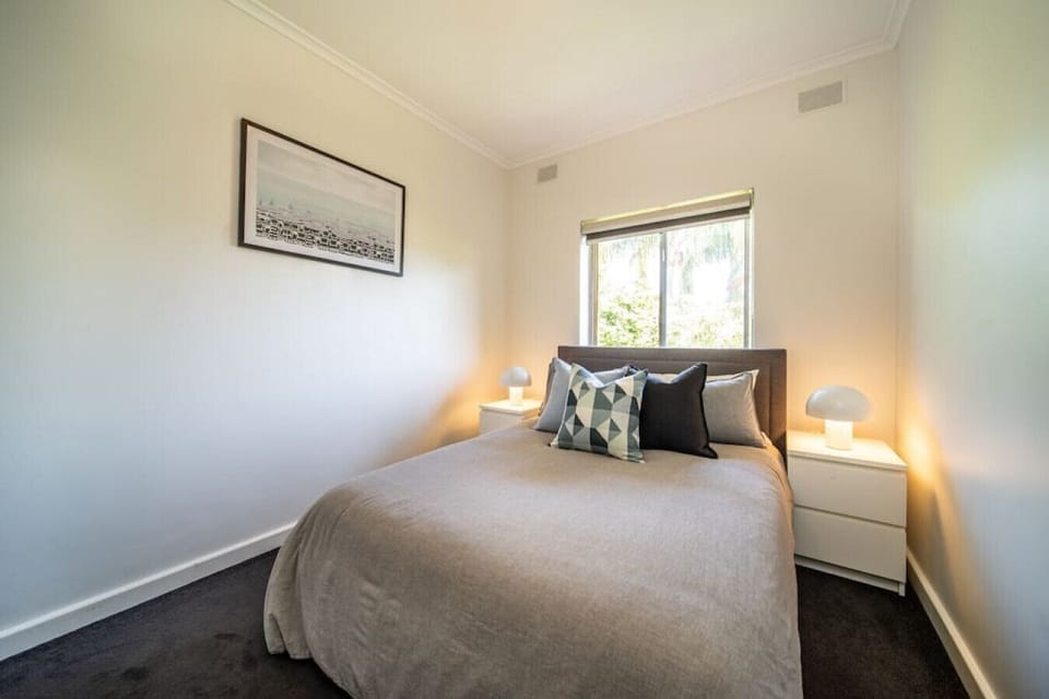 Slip into comfort in the serene second bedroom, featuring soft grey tones, crisp linen, and calming natural light.