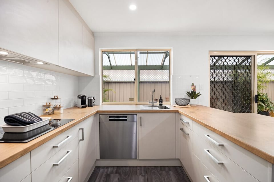 Cook with ease in the fully equipped kitchen featuring a dishwasher, stove, oven, microwave, coffee machine, electric kettle, toaster, and all the cooking essentials for home-style meals.
