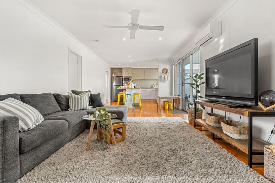 The open-plan living area welcomes you with plush seating, warm tones, and seamless indoor-outdoor flow.