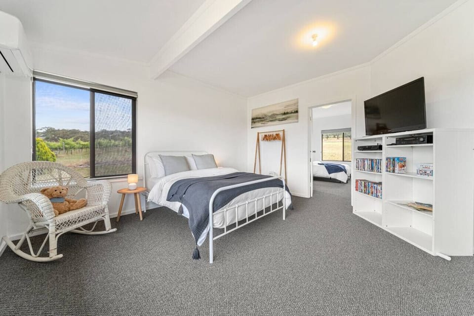 Wake slowly in the primary bedroom featuring a queen bed, rocking chair, and peaceful country outlooks for quiet moments before the day begins.