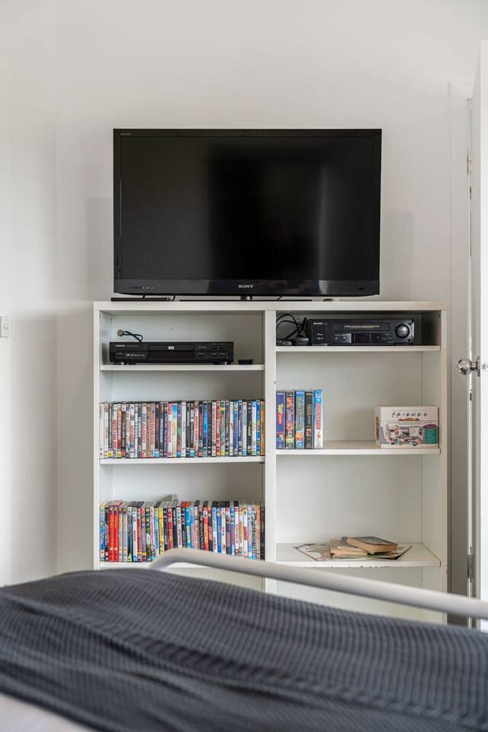 A TV and old-school DVD/VHS collection round out the primary bedroom.