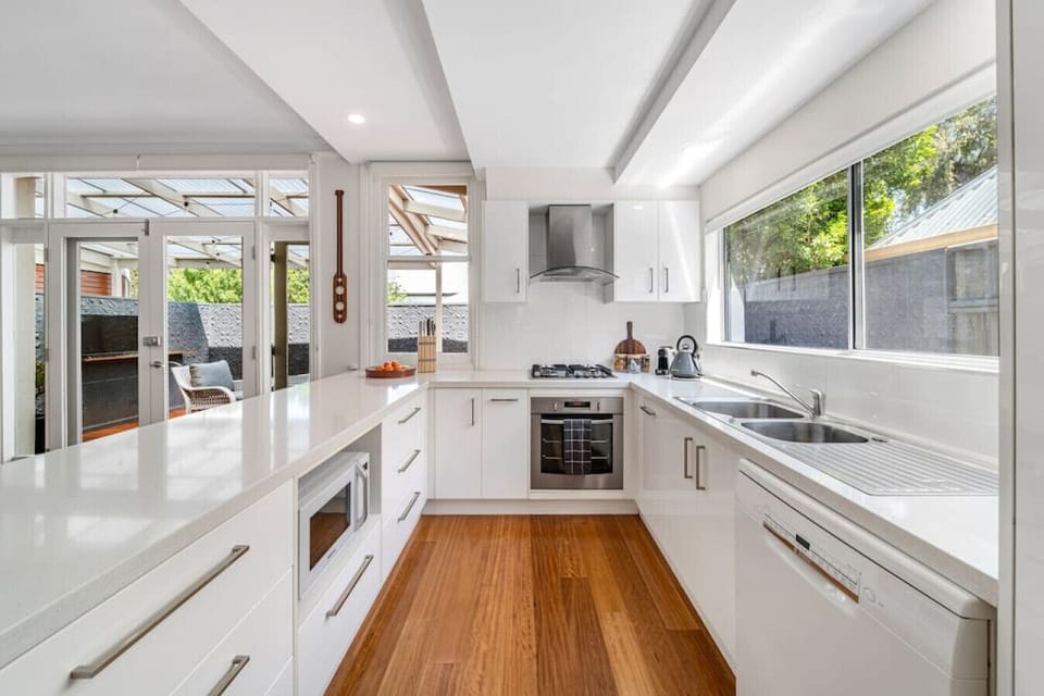 The contemporary kitchen is well set up for the group, with stone benchtops, gas cooktop, and stainless steel appliances throughout.