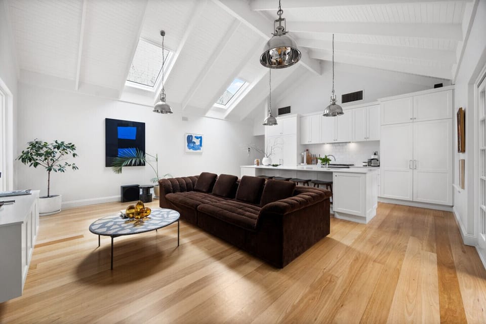 The main living area features cathedral ceilings and skylights, creating an uplifting space for lounging or movie nights on the large TV.
