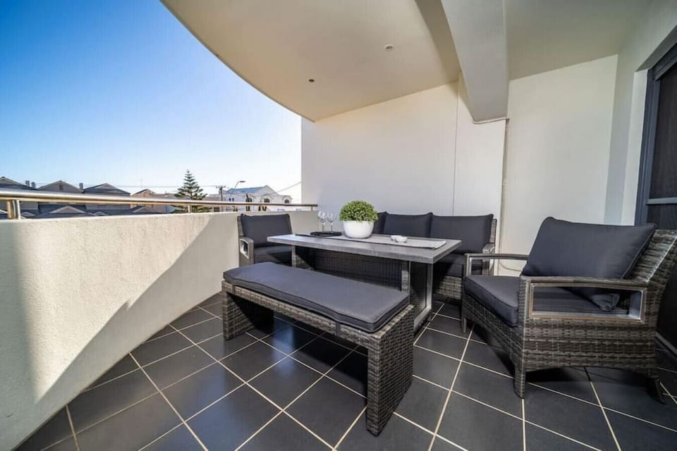 Step out from the living area onto the balcony, where casual seating creates a perfect spot for morning coffee or an evening drink.