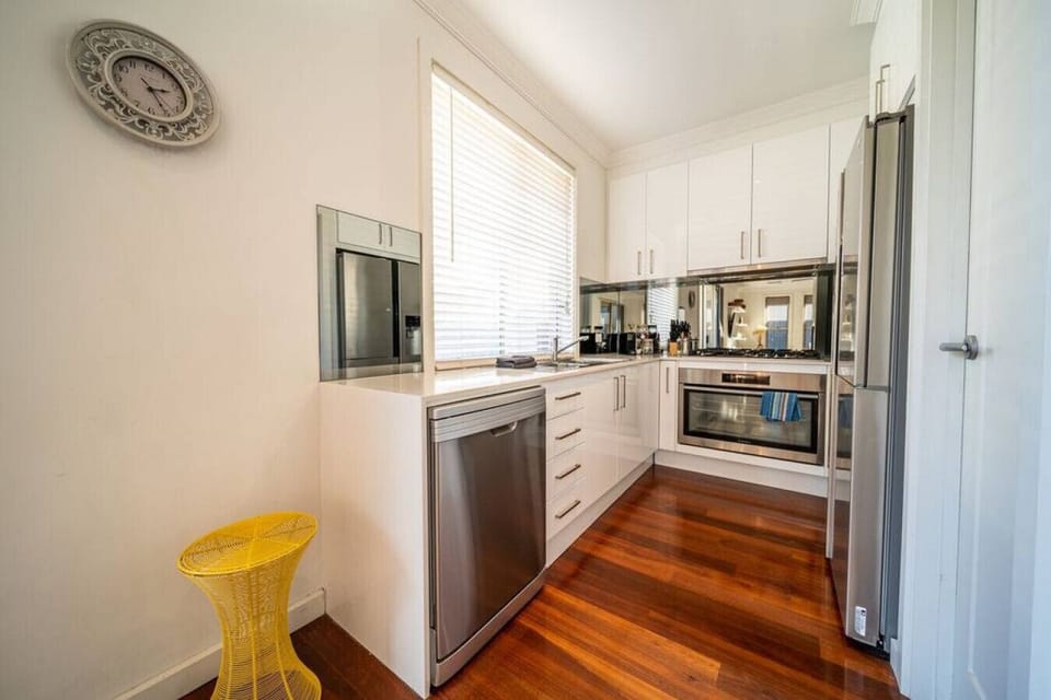 Prepare meals with ease in the fully equipped kitchen featuring an induction cooktop, oven, dishwasher, microwave, fridge, freezer, and all essential cookware.