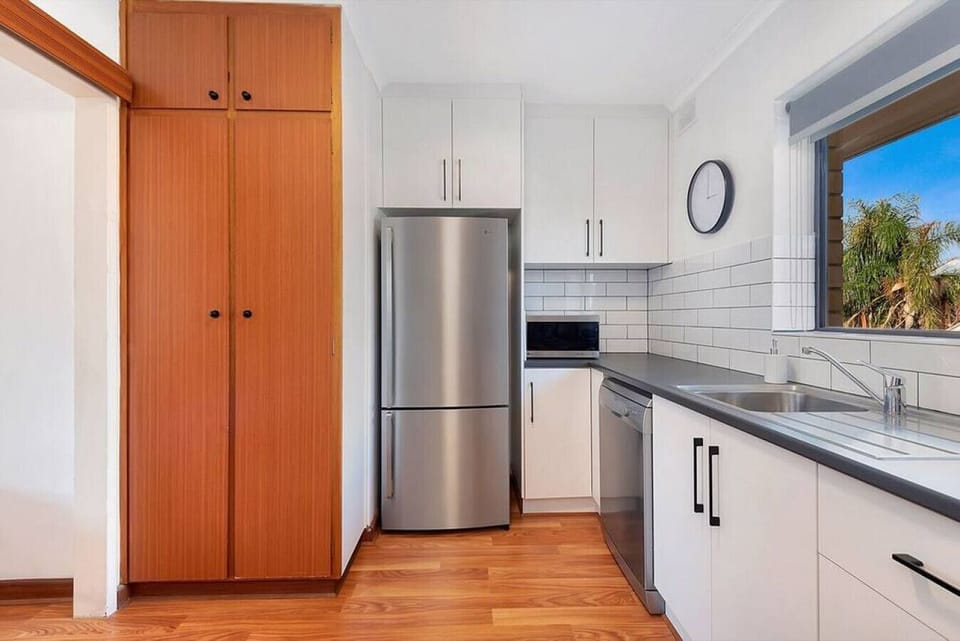 The kitchen is thoughtfully designed with ample storage, a large fridge, and contemporary finishes, making it easy to prepare meals and settle into a comfortable daily rhythm.