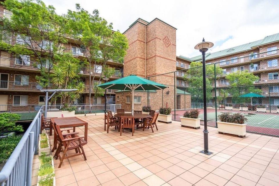 The shared courtyard includes shaded dining areas, adding extra space to relax or share a meal outdoors during your stay.