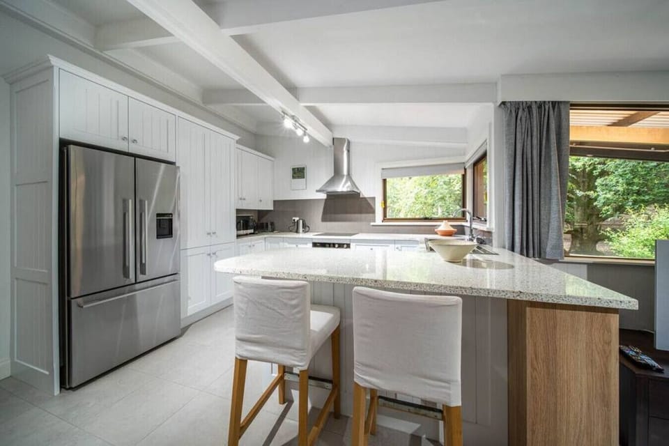 Stainless steel appliances and a stylish range hood add a contemporary touch to the cooking area.