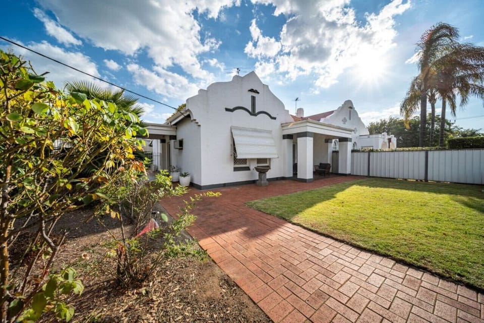 A striking façade framed by lush greenery welcomes you to this timeless home.