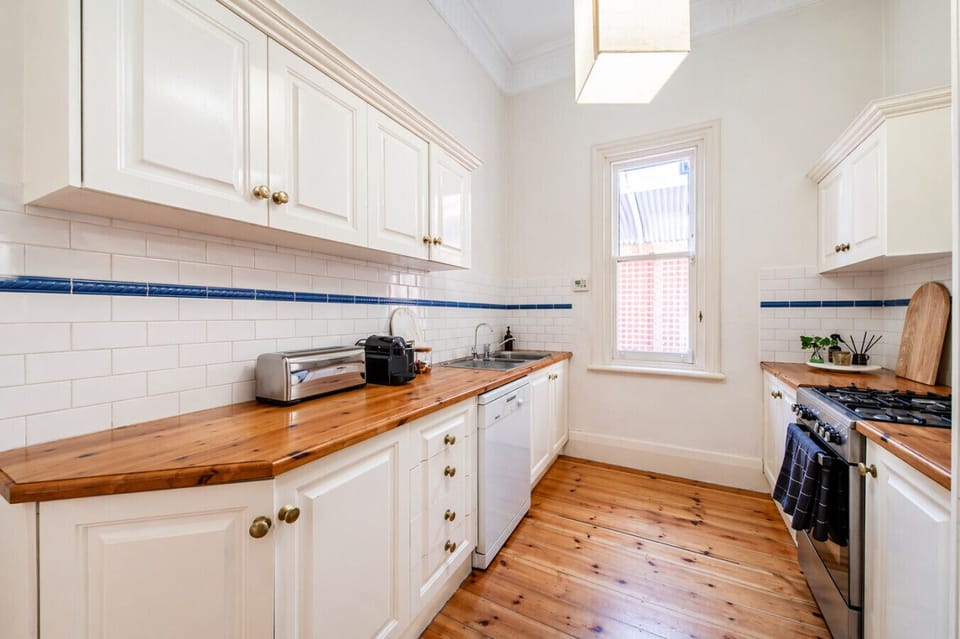 Prepare meals with ease in a bright galley kitchen, complete with warm timber benchtops and everything needed for a comfortable stay.