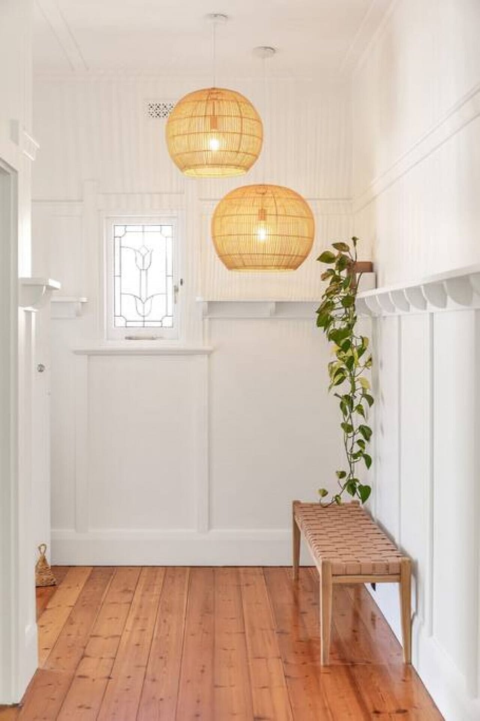 This charming entryway features warm wooden floors, elegant pendant lighting, and thoughtful details.