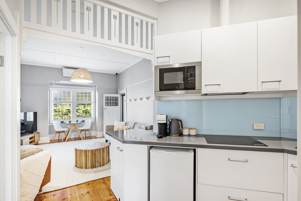 Prepare relaxed holiday meals in the light-filled kitchenette, where practical cooking essentials and open shelving keep the space easy and uncluttered.