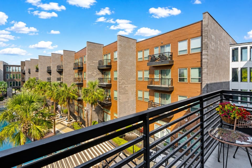 Private balcony with palm-lined courtyard views and a bright resort-style vibe
