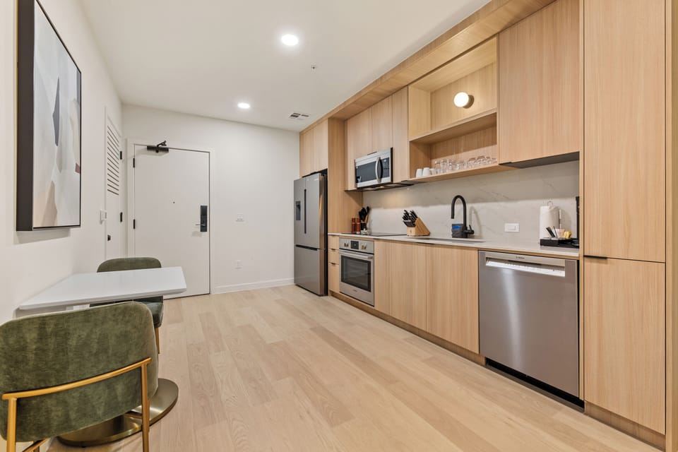 Enjoy an open-concept layout with a sleek full kitchen, cozy lounge seating, and easy access to your private outdoor space.