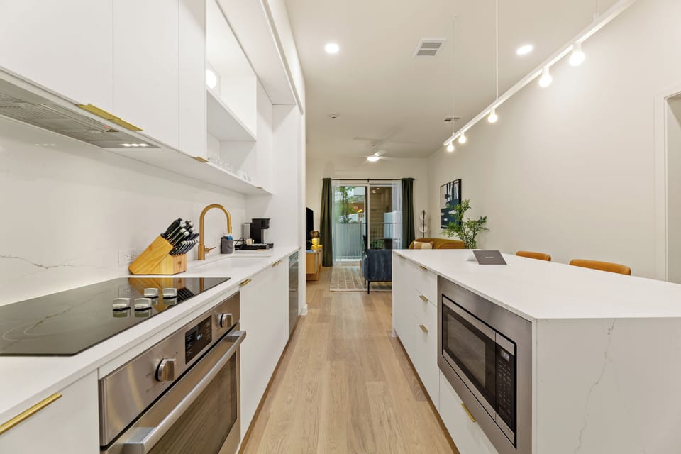 Cook, gather, and unwind in this bright modern kitchen featuring sleek finishes, stainless steel appliances, and island seating for the whole group.