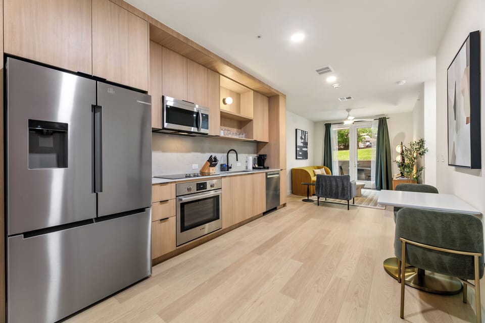 Enjoy an open-concept layout with a sleek full kitchen, cozy lounge seating, and easy access to your private outdoor space.